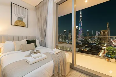 a bedroom with a large window with a view of the city at Vida Dubai Mall! 2 Bedroom with Burj Khalifa View! Direct Access to Dubai Mall in Dubai