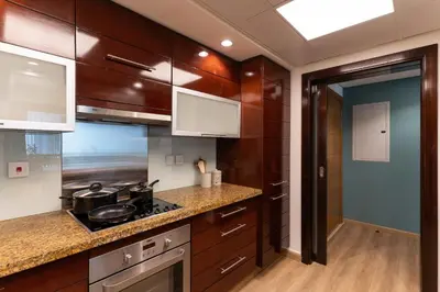 a kitchen with wooden cabinets and a stove at 1BR Apartment next to Dubai Mall & Burj Khalifa in Dubai