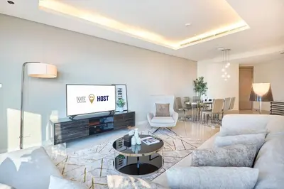 a living room with a couch and a tv at Burj Khalifa View High-Floor Upgraded 3Bed Apt in Dubai