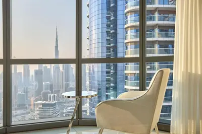 a chair and a table in front of a window at Burj Khalifa View High-Floor Upgraded 3Bed Apt in Dubai