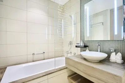 a bathroom with a sink and a tub and a mirror at Burj Khalifa View High-Floor Upgraded 3Bed Apt in Dubai