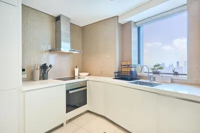 a kitchen with white appliances and a large window at Burj Khalifa View High-Floor Upgraded 3Bed Apt in Dubai