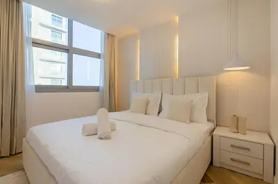 a bedroom with a large white bed with a window at Lux 3 Bedroom apartment in Marina DEC 1103 in Dubai