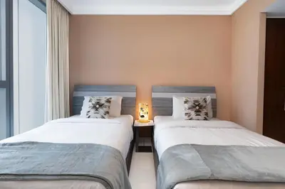 two beds in a small room with a window at Boulevard Point I Burj Khalifa Fireworks View in Dubai