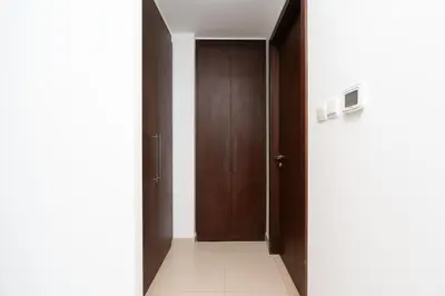 an empty hallway with wooden doors and a white floor at Boulevard Point I Burj Khalifa Fireworks View in Dubai