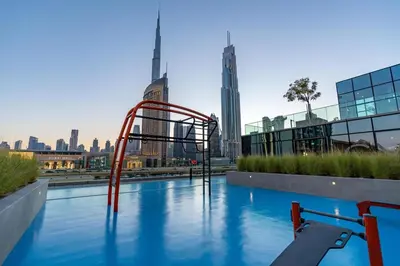 a water slide in a pool with a city skyline at King 2 Bedroom With Burj Khalifa View & Dubai Mall Access in Dubai