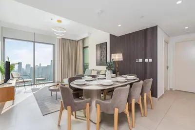 a dining room and living room with a table and chairs at King 2 Bedroom With Burj Khalifa View & Dubai Mall Access in Dubai
