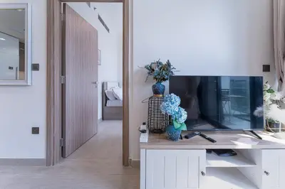 a living room with a tv and a vase of flowers at HAVN - Spacious 1 bedroom in Azizi Riviera, Meydan in Dubai