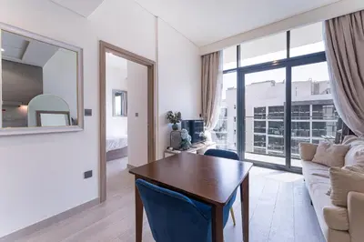 a living room with a table and a couch at HAVN - Spacious 1 bedroom in Azizi Riviera, Meydan in Dubai