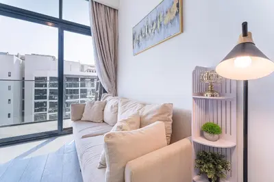 a living room with a white couch and a large window at HAVN - Spacious 1 bedroom in Azizi Riviera, Meydan in Dubai