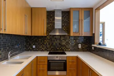 a kitchen with wooden cabinets and a stove top oven at Two Bedroom apartment - Dubai Marina in Dubai