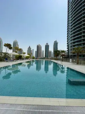 a large swimming pool with a city skyline in the background at Two Bedroom apartment - Dubai Marina in Dubai