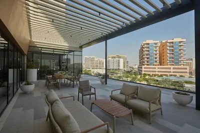 a balcony with chairs and tables and a view of a city at Casa Haven Retreat in Dubai