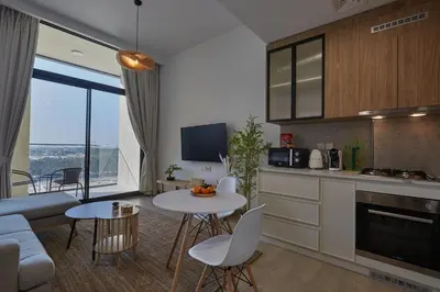 a kitchen and living room with a table and chairs at Casa Haven Retreat in Dubai