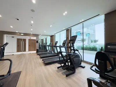 a gym with a row of treadmills at StayShort - Stylish Boho Studio in JVC Dubai Staycation Sleeps 2 in Dubai