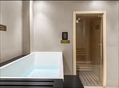 a large bath tub in a room with a hallway at Studio Apartments with Private Jacuzzi - Spa - Cold Plunge - Gym in Business Bay in Dubai