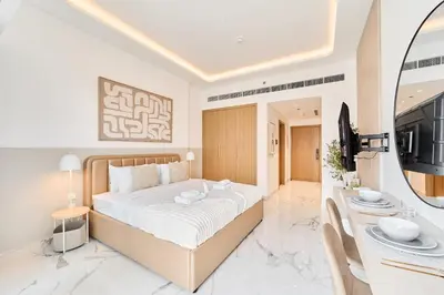 a bedroom with a large bed and a television at Cozy & Modern Studio Stay in Azizi Riviera Meydan in Dubai
