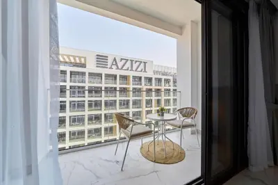 a balcony with a table and chairs and a building at Cozy & Modern Studio Stay in Azizi Riviera Meydan in Dubai
