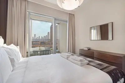 a bedroom with a large white bed with a large window at Luxury 4BR Burj Khalifa View Dubai Mall in Dubai