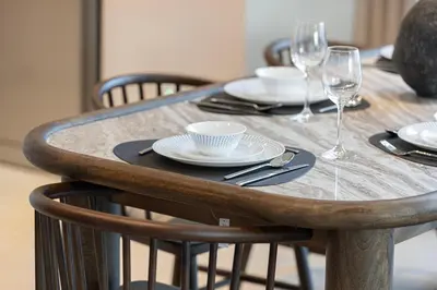 a wooden table with plates and wine glasses on it at Luxury 4BR Burj Khalifa View Dubai Mall in Dubai
