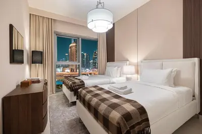 two beds in a hotel room with a view of a city at Luxury 4BR Burj Khalifa View Dubai Mall in Dubai