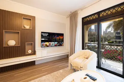 a living room with a tv and a chair at Luxury 2BR in Dubai Downtown Steps to Burj Khalifa and Dubai Mall with Burj Khalifa View by La Brisa in Dubai