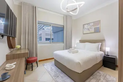 a bedroom with a bed and a desk and a tv at Prestigious 2BR with nice View of Marina Dubai in Dubai