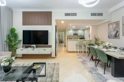 a living room with a large television and a dining room at Prestigious 2BR with nice View of Marina Dubai in Dubai