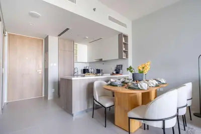 a kitchen and dining room with a wooden table and chairs at Frank Porter - Liv Marina in Dubai