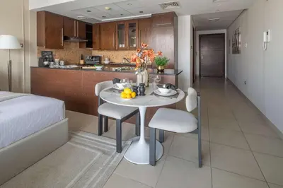 a room with a table and chairs and a kitchen at Frank Porter - Boulevard Walk Downtown in Dubai