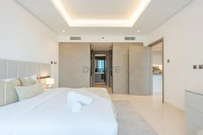 a bedroom with a large white bed and a bathroom at Burj Khalifa Views, Walking Distance to Dubai Mall and Downtown Boulevard - The Sterling West House, Business Bay by Deluxe Holiday Homes in Dubai