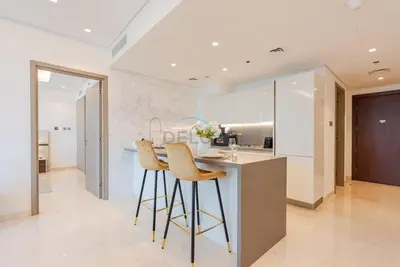 a kitchen with two bar stools and a counter at Burj Khalifa Views, Walking Distance to Dubai Mall and Downtown Boulevard - The Sterling West House, Business Bay by Deluxe Holiday Homes in Dubai