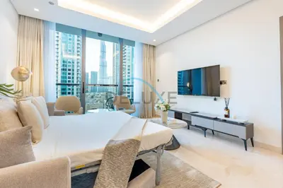 a living room with a large bed and a television at Burj Khalifa Views, Walking Distance to Dubai Mall and Downtown Boulevard - The Sterling West House, Business Bay by Deluxe Holiday Homes in Dubai