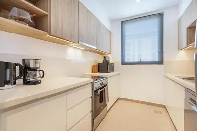 a kitchen with white cabinets and a window at Luxury Modern Home with Direct Park Access in Dubai