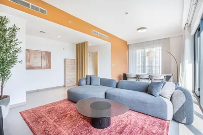 a living room with a blue couch and a table at Luxury Modern Home with Direct Park Access in Dubai