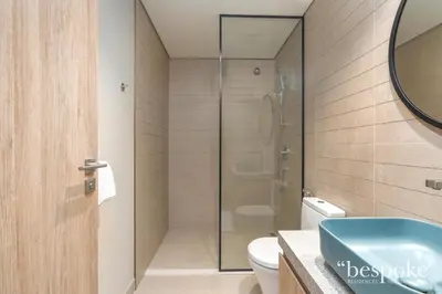 a bathroom with a glass shower and a toilet at Bespoke Holiday Homes - Elegant 2BR Waterfront Stay with Canal View in Dubai