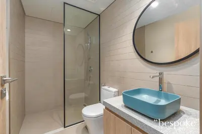 a bathroom with a toilet and a sink and a mirror at Bespoke Holiday Homes - Elegant 2BR Waterfront Stay with Canal View in Dubai