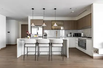 a kitchen with a large island with bar stools at Luxurious Bliss - 3-BR plus maids - Grand Bleu by Elie Saab in Dubai