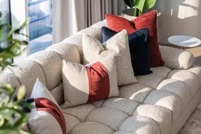 a couch with pillows on it in a living room at Luxurious Bliss - 3-BR plus maids - Grand Bleu by Elie Saab in Dubai