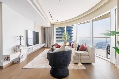 a living room with a couch and a tv at Luxurious Bliss - 3-BR plus maids - Grand Bleu by Elie Saab in Dubai