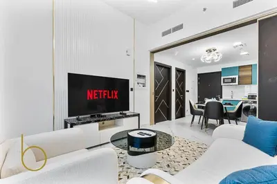 a living room with a white couch and a tv at Bookable 1 Bed in Opalz by Danube in Dubai