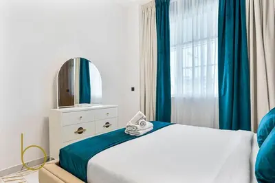 a bedroom with a bed with a mirror and a window at Bookable 1 Bed in Opalz by Danube in Dubai