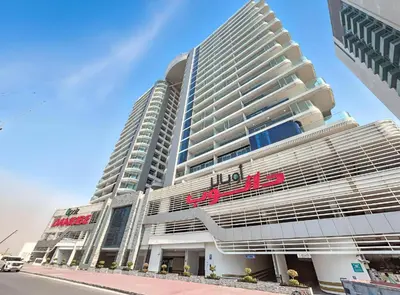 a large building with a hilton sign on it at Bookable 1 Bed in Opalz by Danube in Dubai
