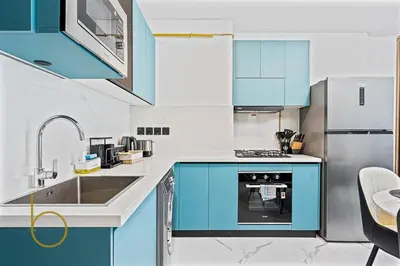 a kitchen with blue cabinets and a sink at Bookable 1 Bed in Opalz by Danube in Dubai
