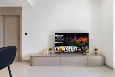 a living room with a flat screen tv on a wall at Stylish Family Retreat That Sleeps 6 In The Heart of JVC in Dubai