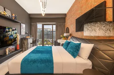 a bedroom with a large bed and a dining room at Daniels Studio at Meydan with Community View in Dubai