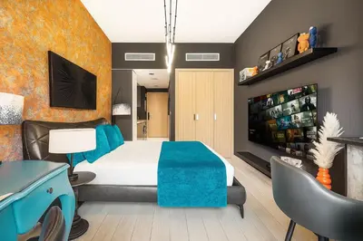a bedroom with a large bed and a tv at Daniels Studio at Meydan with Community View in Dubai