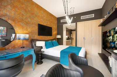 a hotel room with a bed and a desk and chairs at Daniels Studio at Meydan with Community View in Dubai