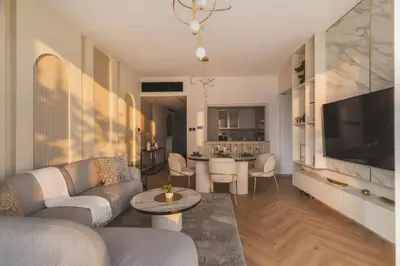 a living room with a couch and a tv and a table at Fountain & Opera Views 1 Bedroom Apartment with Balcony in Dubai