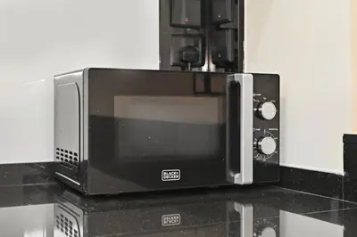 a microwave oven sitting on top of a counter at Relax in Comfort with Modern Amenities, Steps from Burj Khalifa and Dubai Mall in Dubai